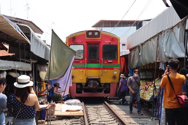 The Maeklong Railway train arriving in the market